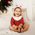 Baby in a red knitted Christmas bubble romper
