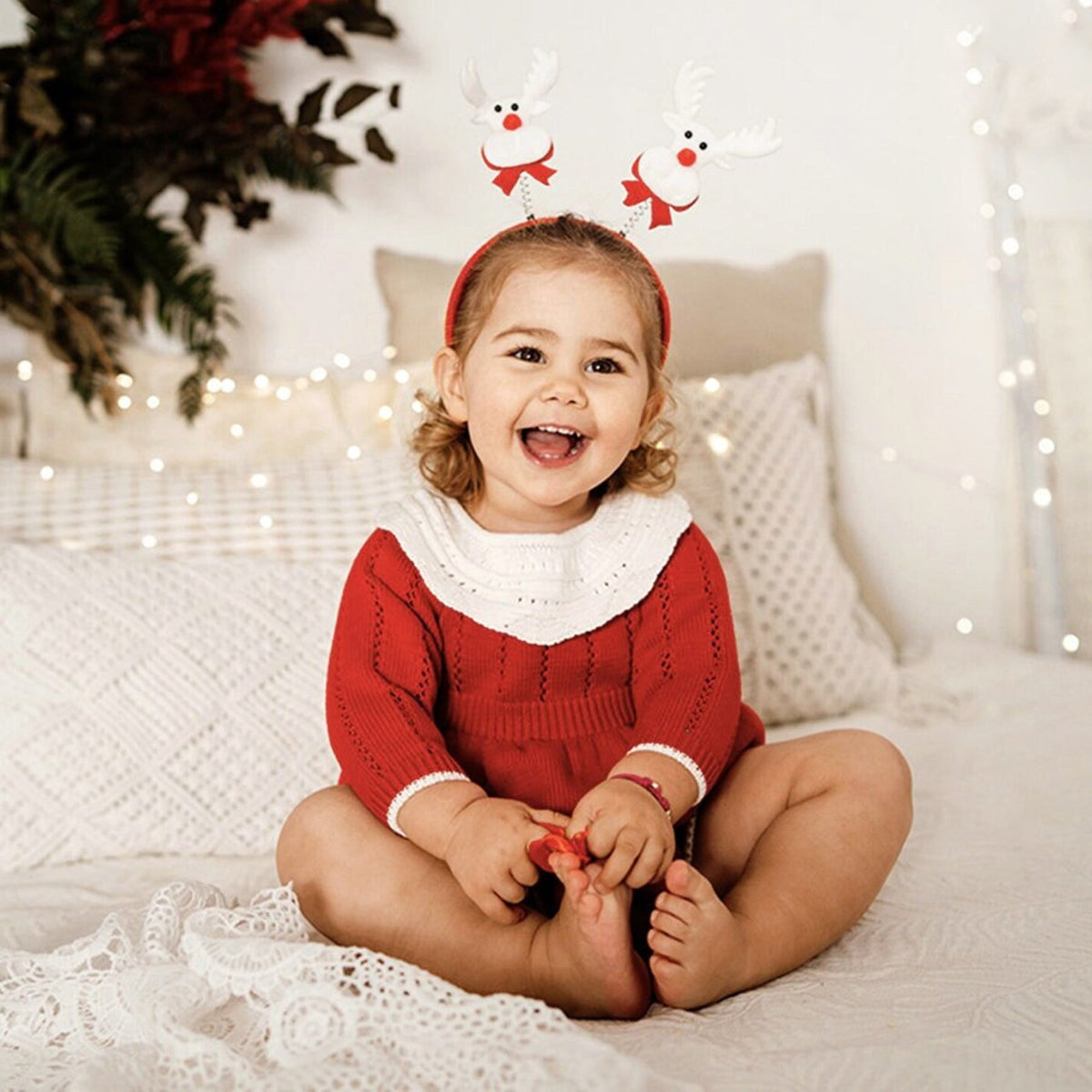 Baby in a red knitted Christmas bubble romper