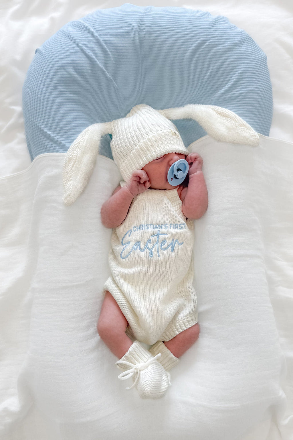 Classic knitted romper worn by a newborn, personalised embroidery version