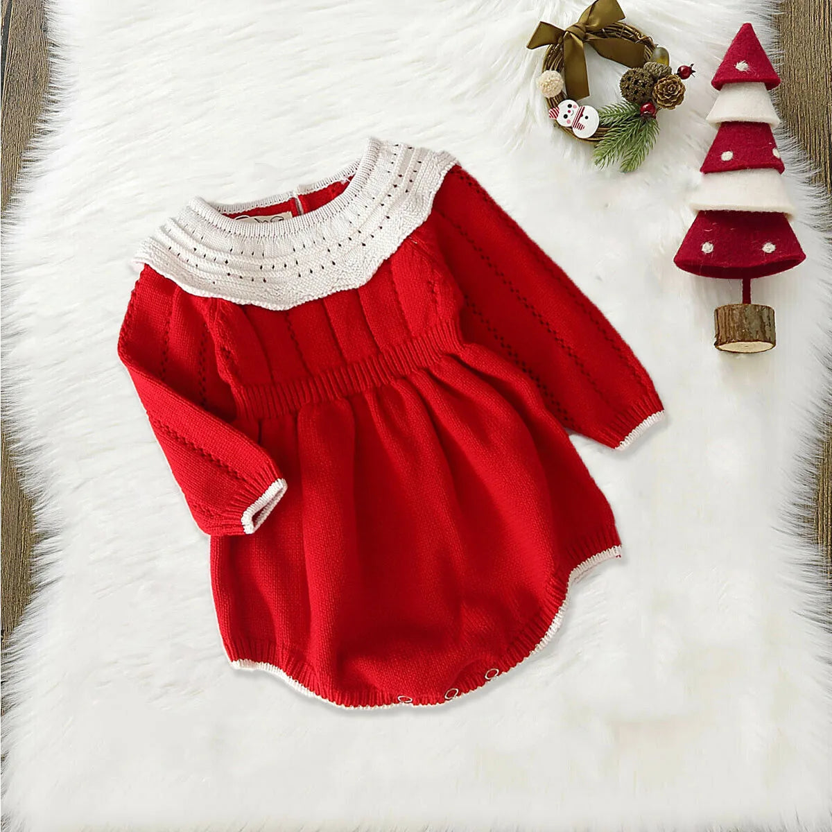 Red knitted Christmas romper dress with white lace collar, flat lay