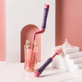 Silicone bottle brush with rotating handle cleaning a baby bottle, with nipple brush