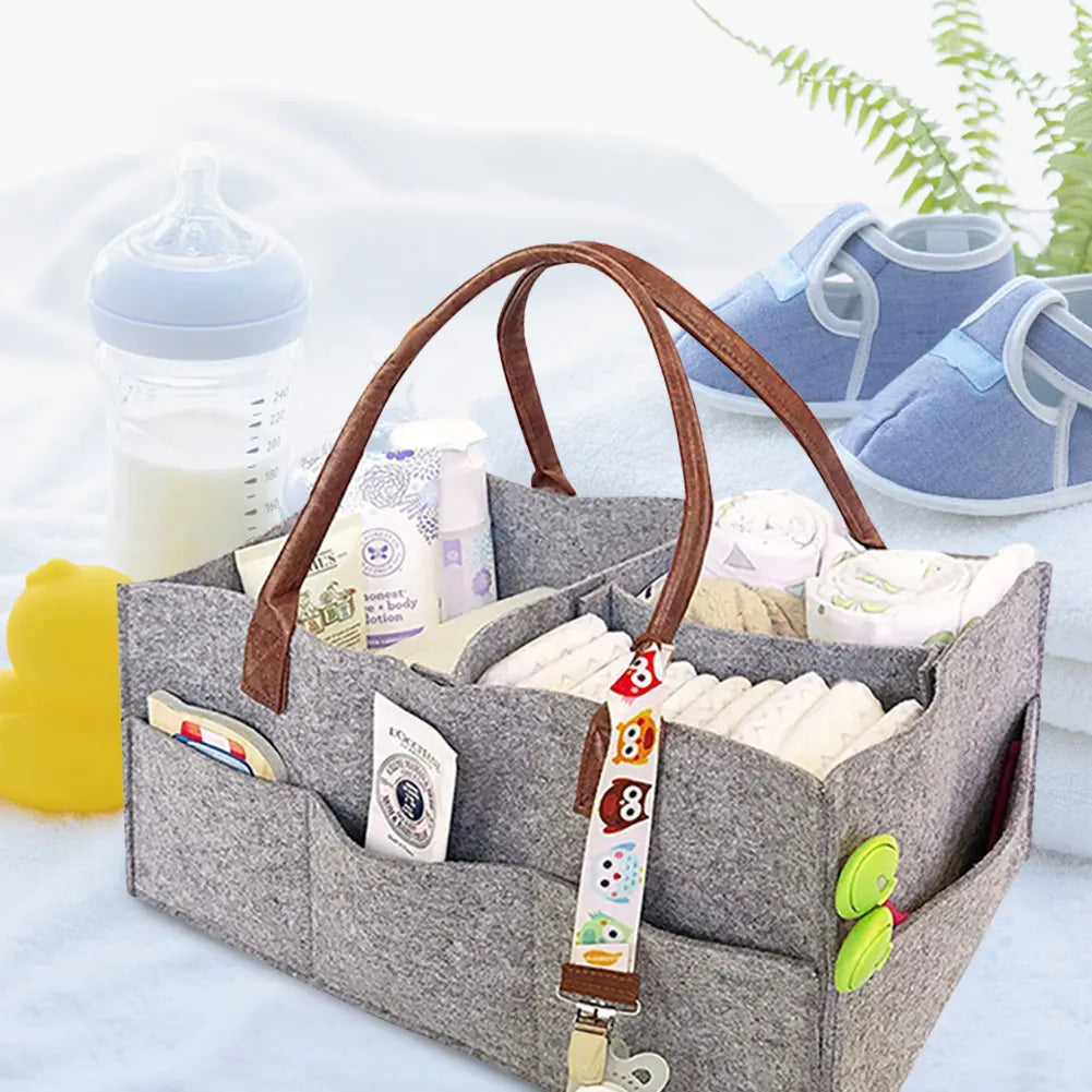 Felt diaper caddy organizer filled with nappies and bottles, nursery scene